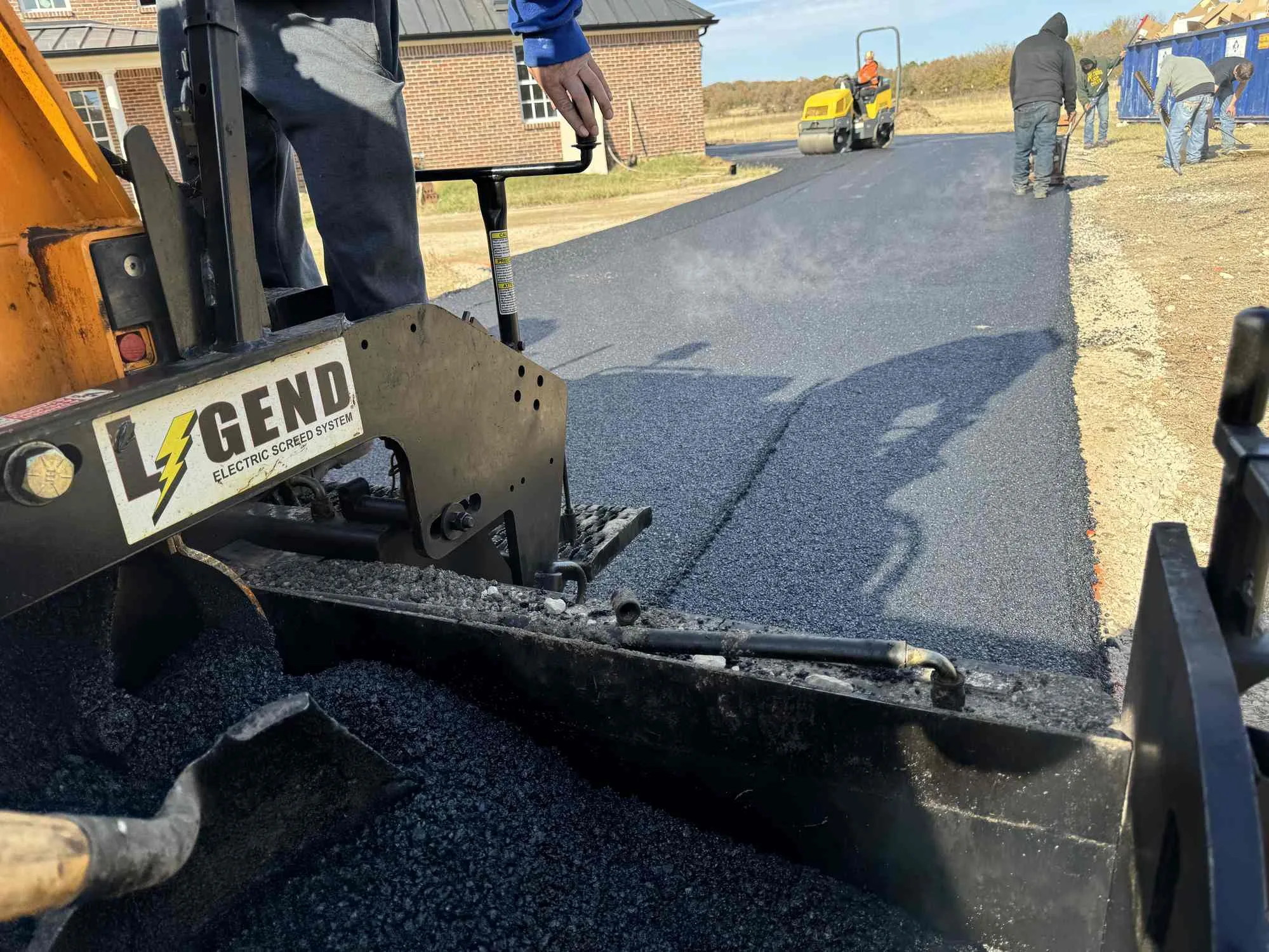 Fresh asphalt paving crew working on a driveway