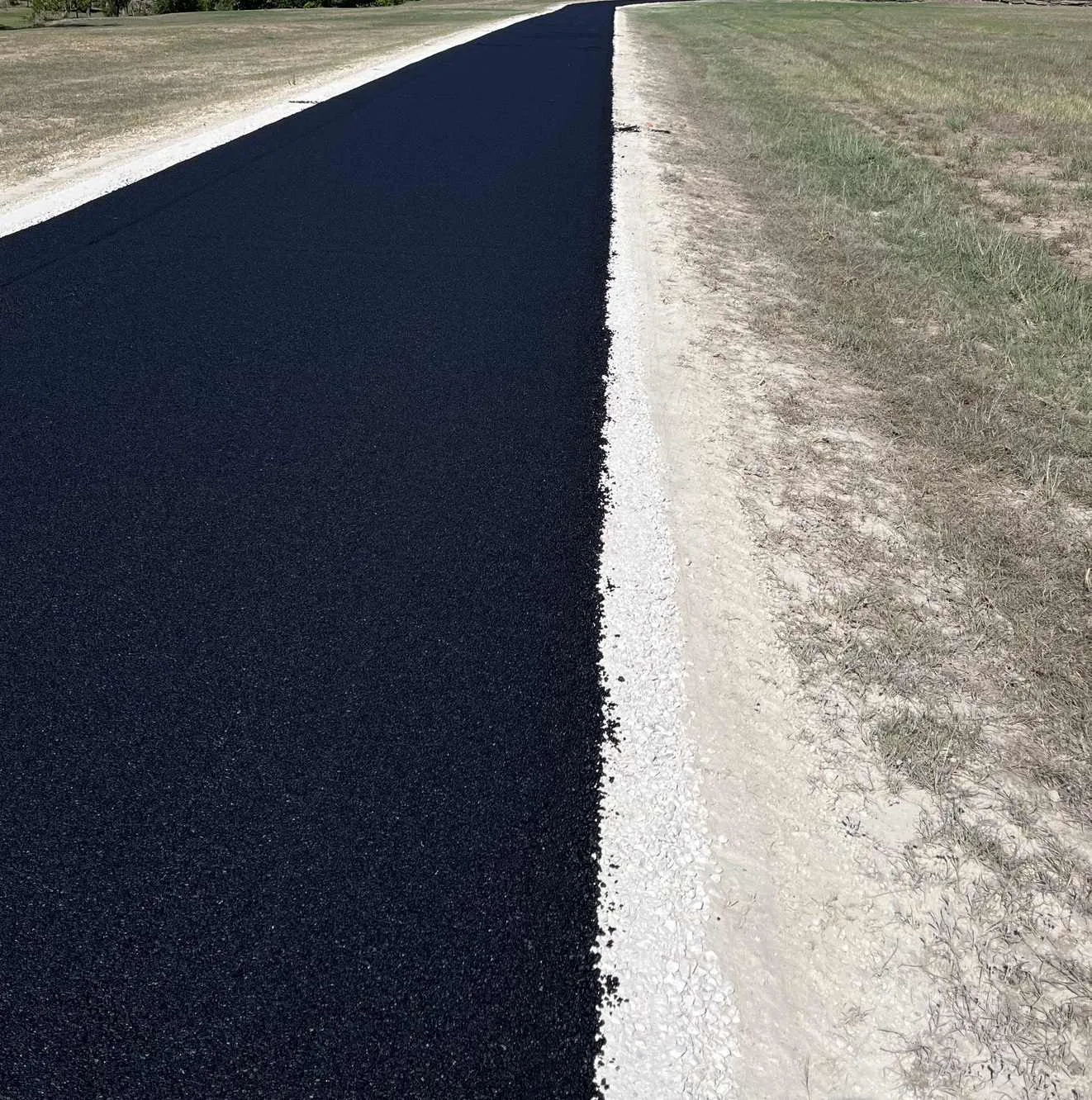Fresh asphalt edge next to gravel shoulder